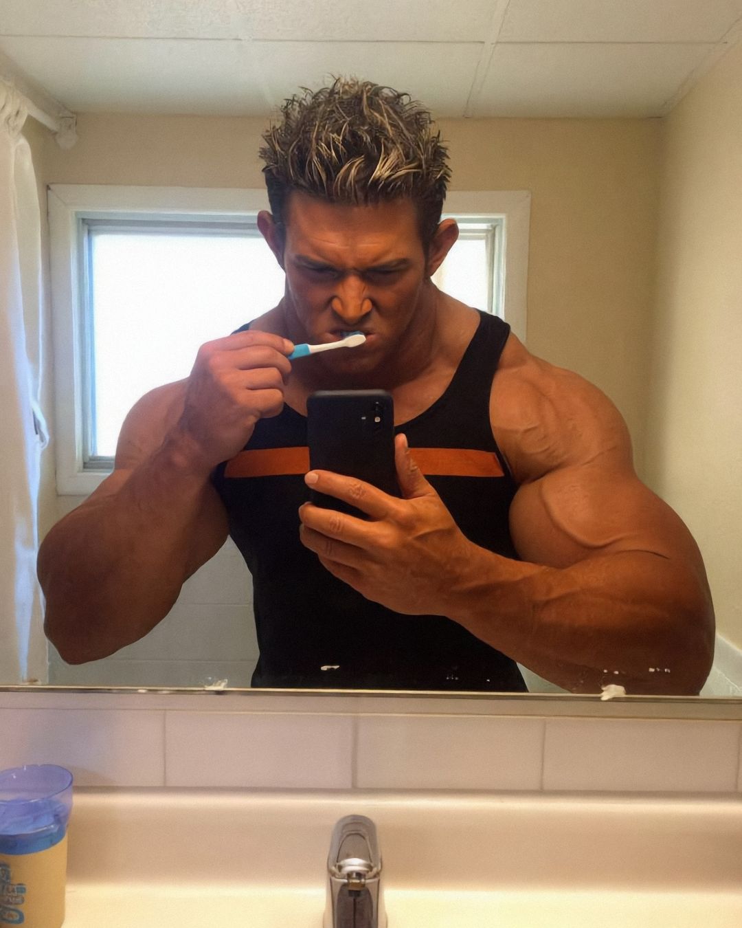 Elon Muskle brushing his teeth while taking a bathroom mirror selfie